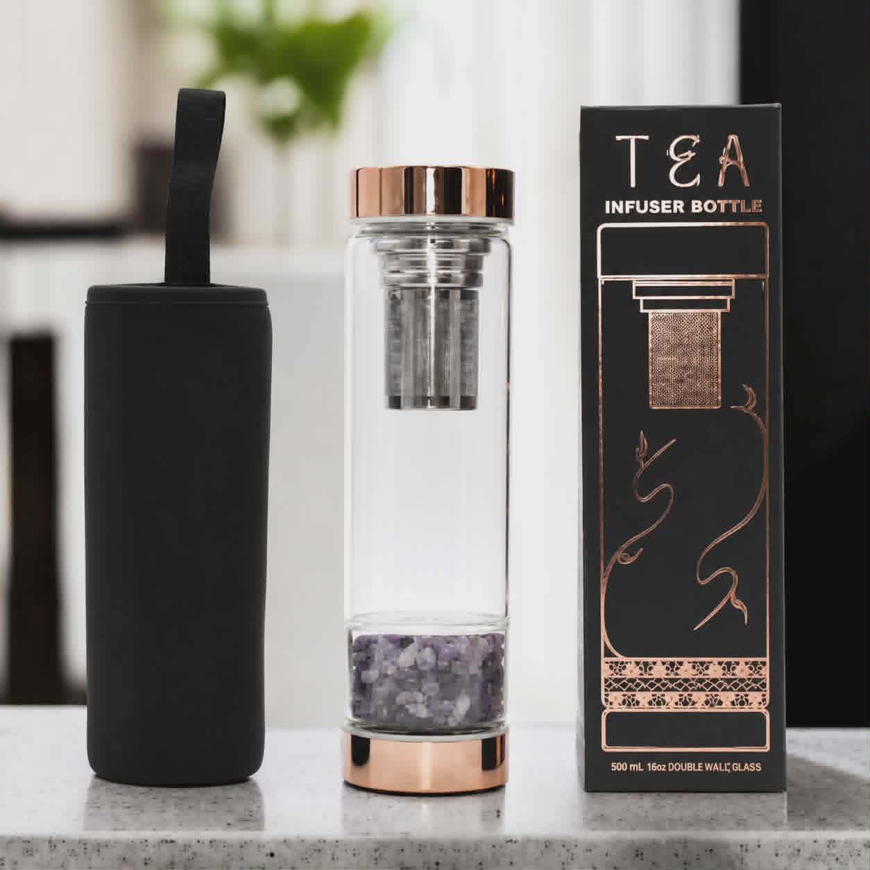 Crystal glass infusion bottle with infuser and rose gold design beside neoprene sleeve
