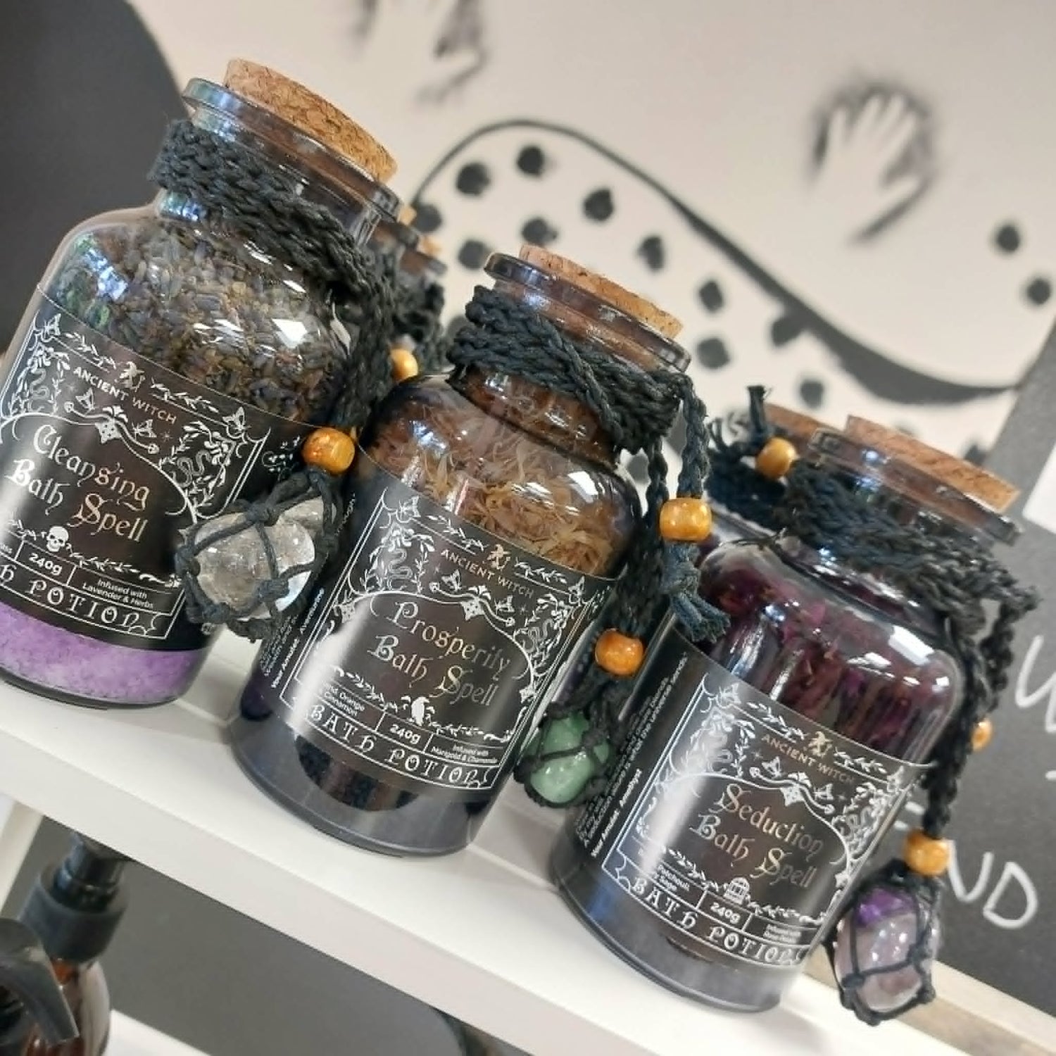 Glass bottles with cork lids filled with Himalayan bath salts, essential oils and botanicals with crystal amulets