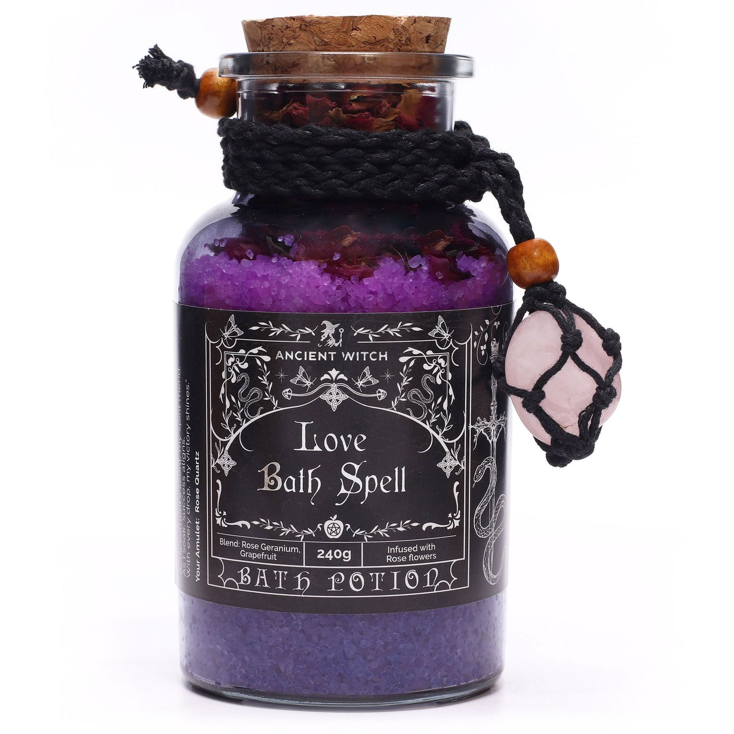 Glass bottle with cork lid filled with Himalayan bath salts and rose petals infused with Rose Geranium and Grapefruit essential oils with a Rose Quartz crystal amulet