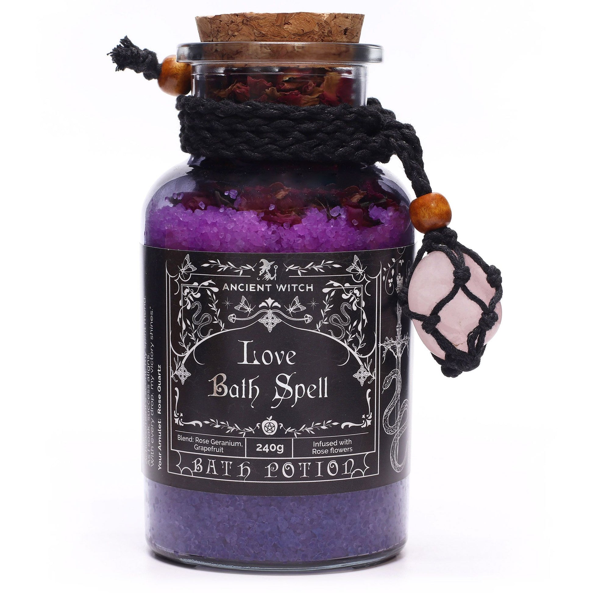 Glass bottle with cork lid filled with Himalayan bath salts and rose petals infused with Rose Geranium and Grapefruit essential oils with a Rose Quartz crystal amulet