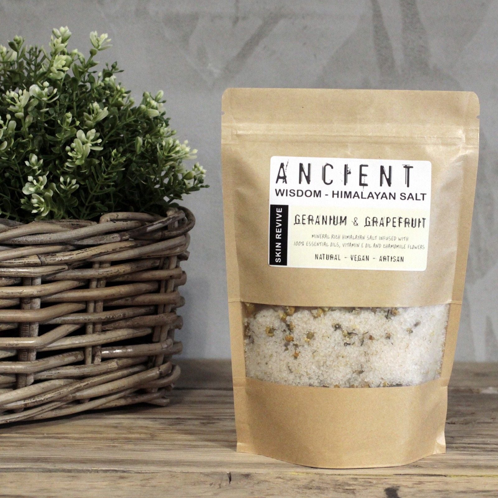 Resealable paper bag of Himalayan bath salts infused with Geranium and Grapefruit essential oils, Vitamin E Oil and Chamomile flowers