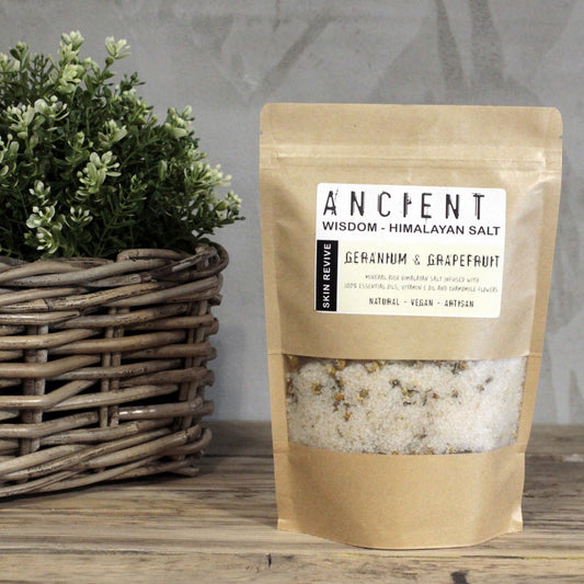 Resealable paper bag of Himalayan bath salts infused with Geranium and Grapefruit essential oils, Vitamin E Oil and Chamomile flowers