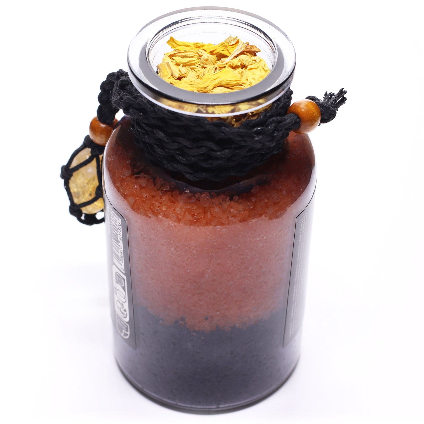 Glass bottle with cork lid off filled with Himalayan bath salts, sunflower petals and Bergamot essential oil with a Citrine crystal amulet from above